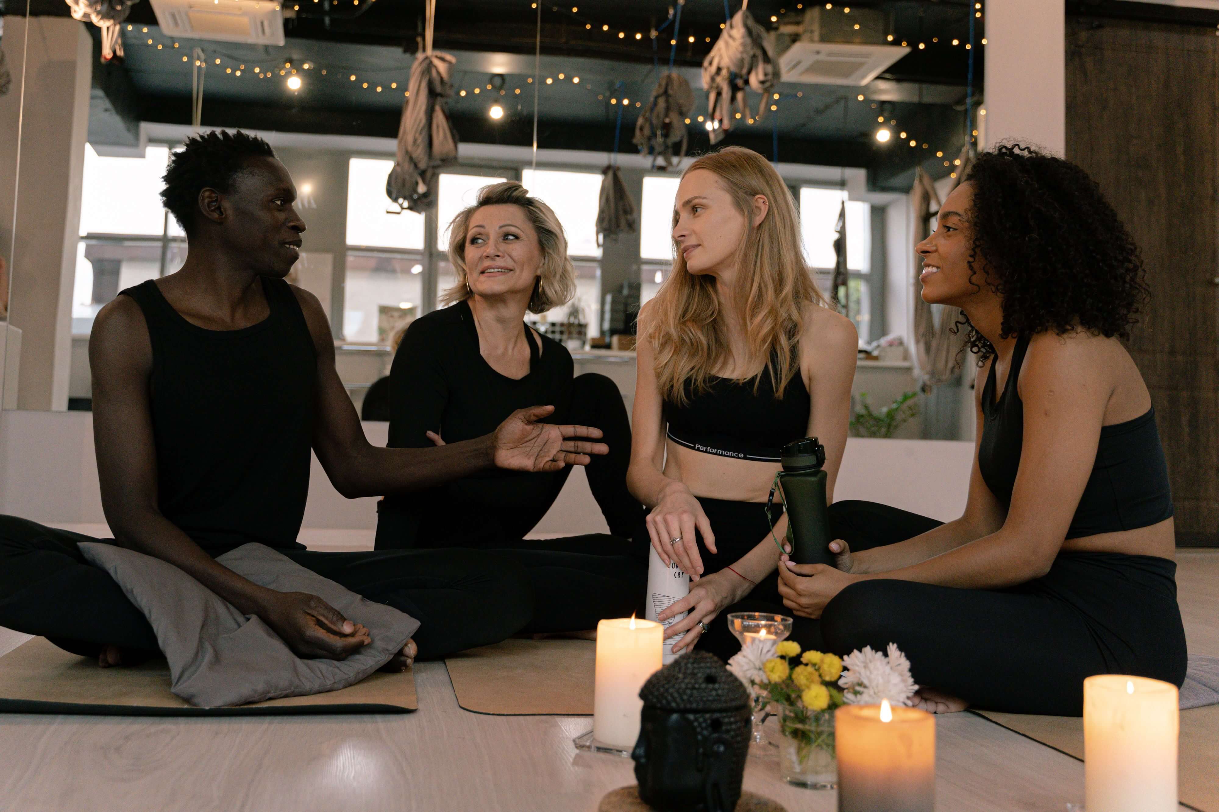 A diverse group of adults engaged in relaxation and meditation in a cozy yoga studio setting.